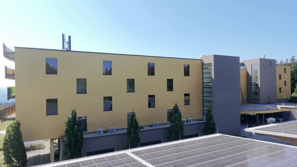 Gesamtansicht des sanierten Hotelgebäudes AVIVA im Mühlviertel mit neuer Fassade in Gold und Anthrazit.